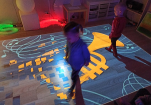 Dzieci bawią się na podłodze interaktywnej.